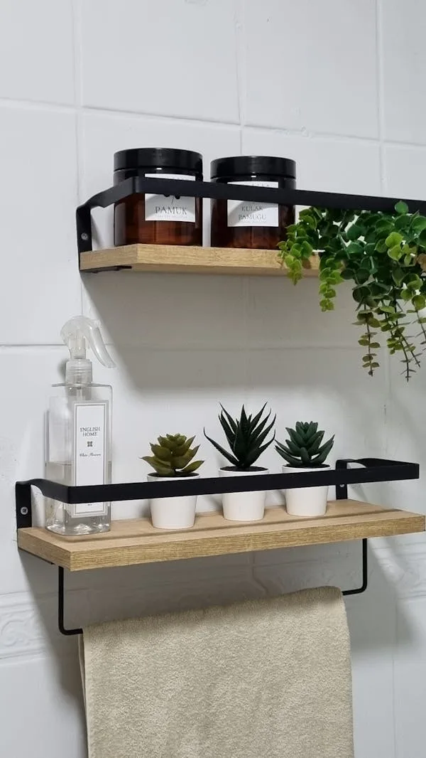Mini artificial plants placed on a wooden hanging shelf over the bathroom sink